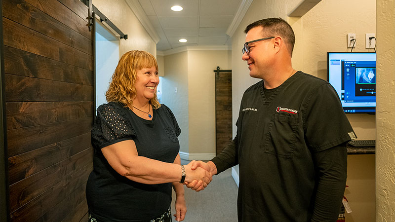 patient and doctor shaking hands after dental procedure within the dental center